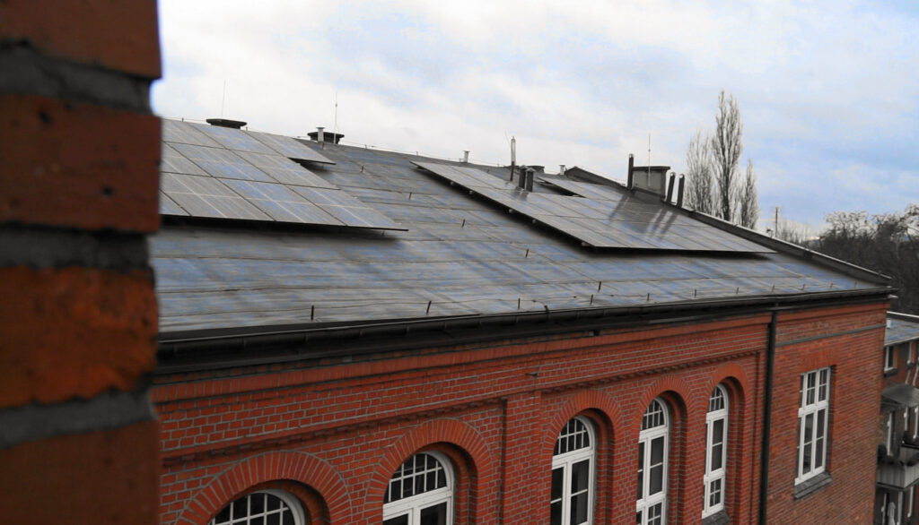 Panele fotowoltaiczne na dachu budynku szkolnego