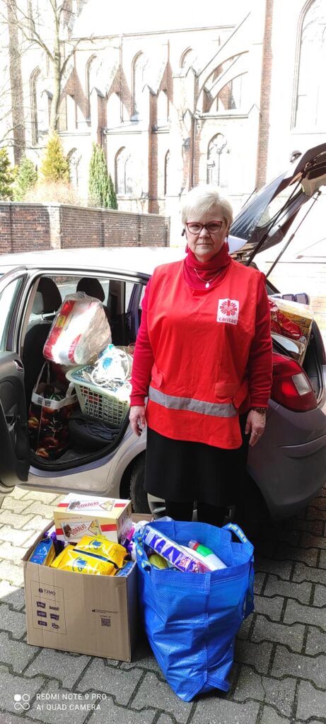 Przedstawiciele Caritas pakujący dary