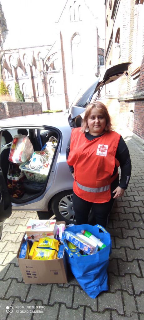 Przedstawiciele Caritas pakujący dary