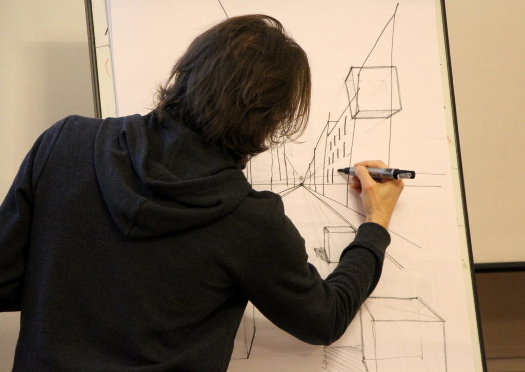 Uczeń wykonujący rysunek na desce kreślarskiej