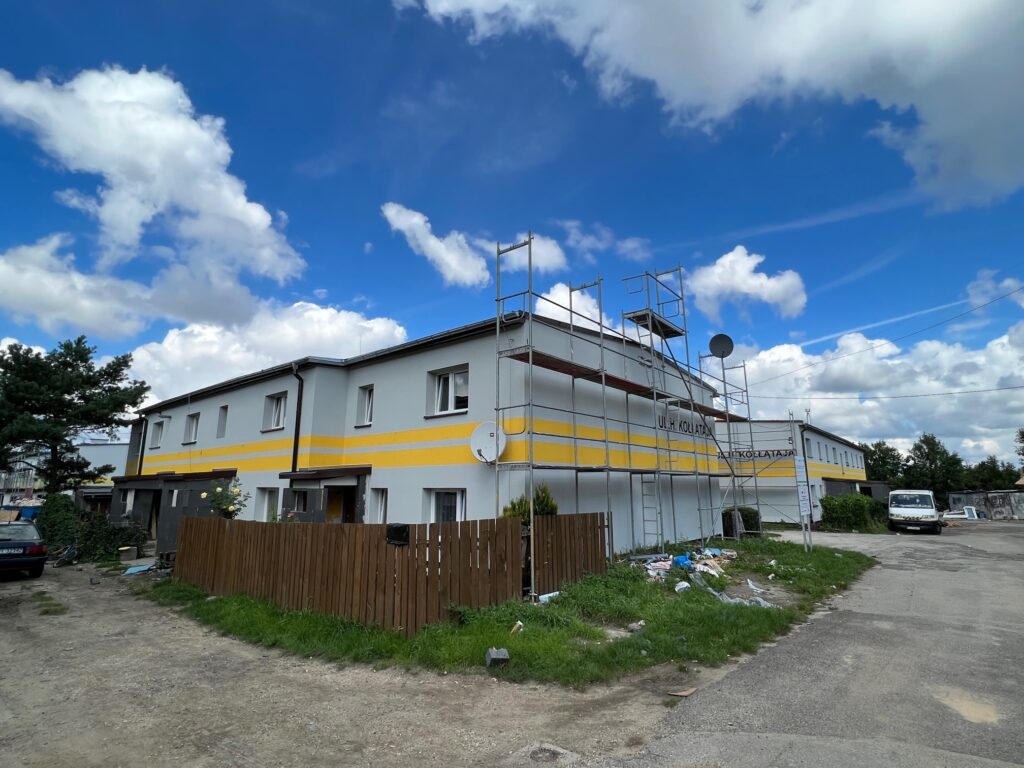 Budynek w trakcie termomodernizacji. Przy budynku stoją rusztowania