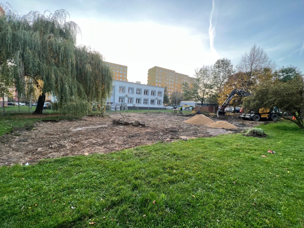 Trwające prace budowlane na terenie  pomiędzy ul. Wyzwolenia 19 a ul. Stawową 18, w tle bloki i budynek PUP oraz koparka.