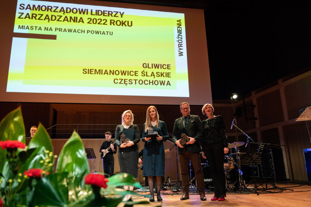 Grupa osób stojąca na scenie w czasie gali