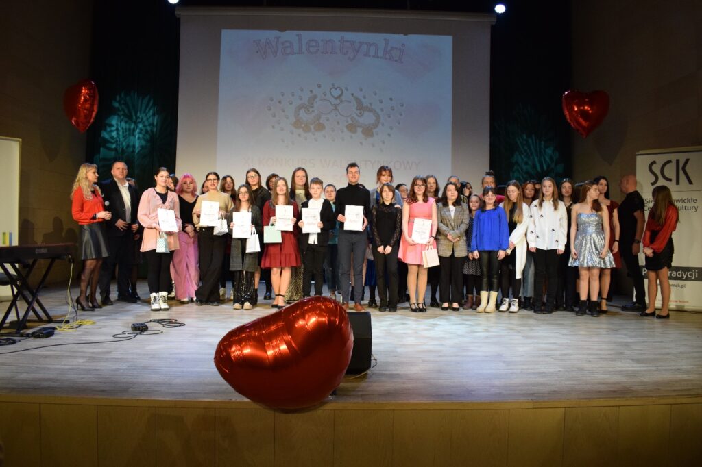 Zdjęcie grupowe uczestników konkursu, przed nimi balon : czerwone serce