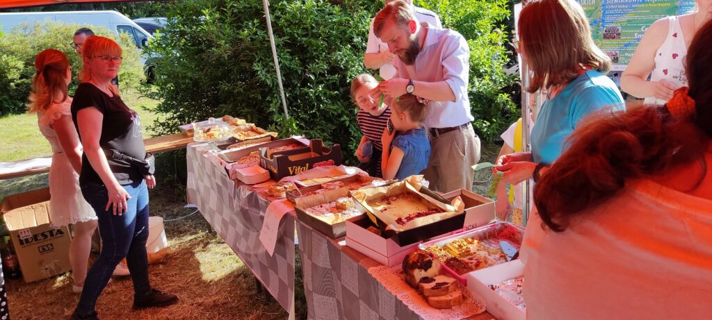 Osoby przy kiermaszu ciast