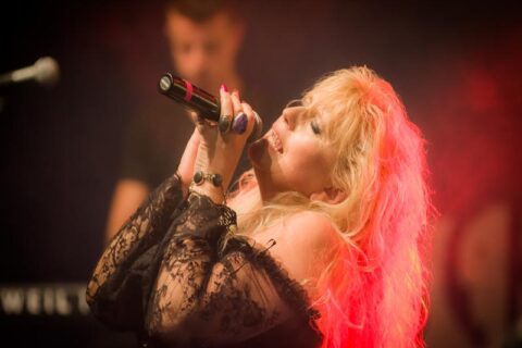 Na zdjęciu gwiazda muzyki country - Alicja Boncol, na scenie, podczas koncertu, śpiewająca do mikrofonu