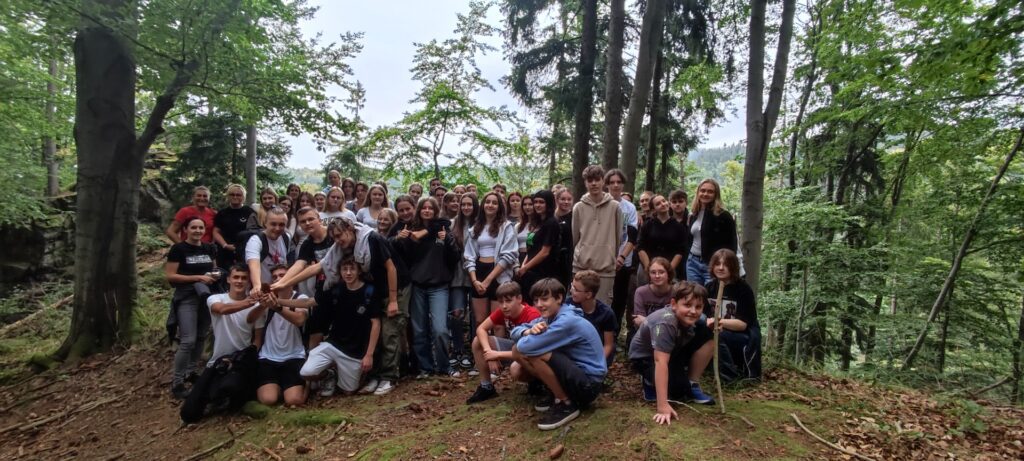 Grupa młodzieży z opiekunami w lesie