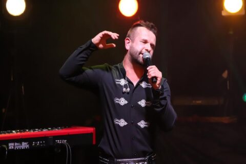 Na scenie SCK - Bytków ubrany w czarny strój wokalista Paweł Gołecki