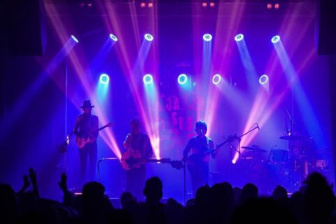 Widok na scenę SCK - Bytków oświetloną niebieskimi i różowymi światłami, podczas koncertu zespołu Karaś Rogucki
