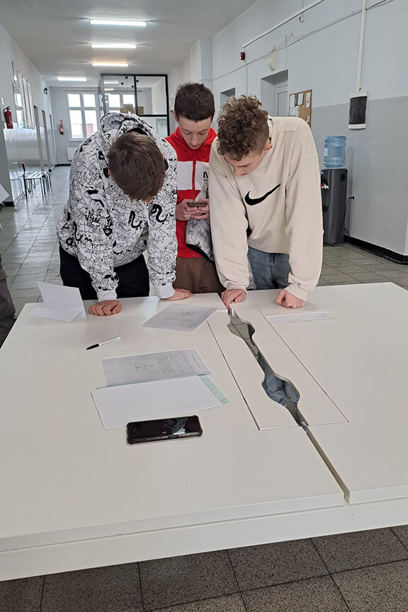 Uczniowie rozwiązują zadania na jednej ze stacji.