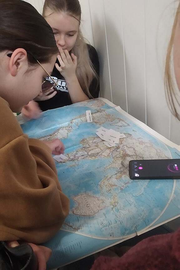 Uczniowie przyglądają się mapie.