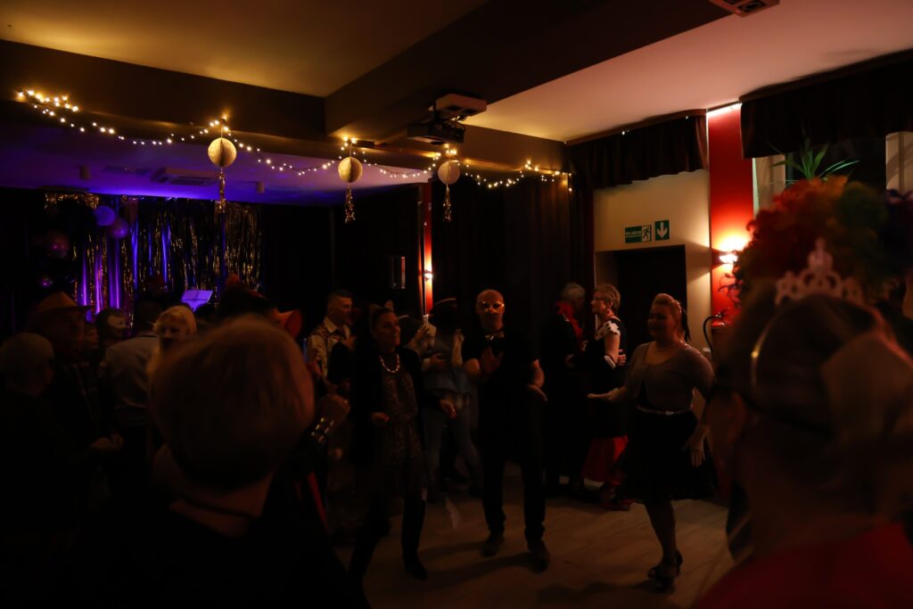 Parkiet pełen tańczących ludzi na balu przebierańców