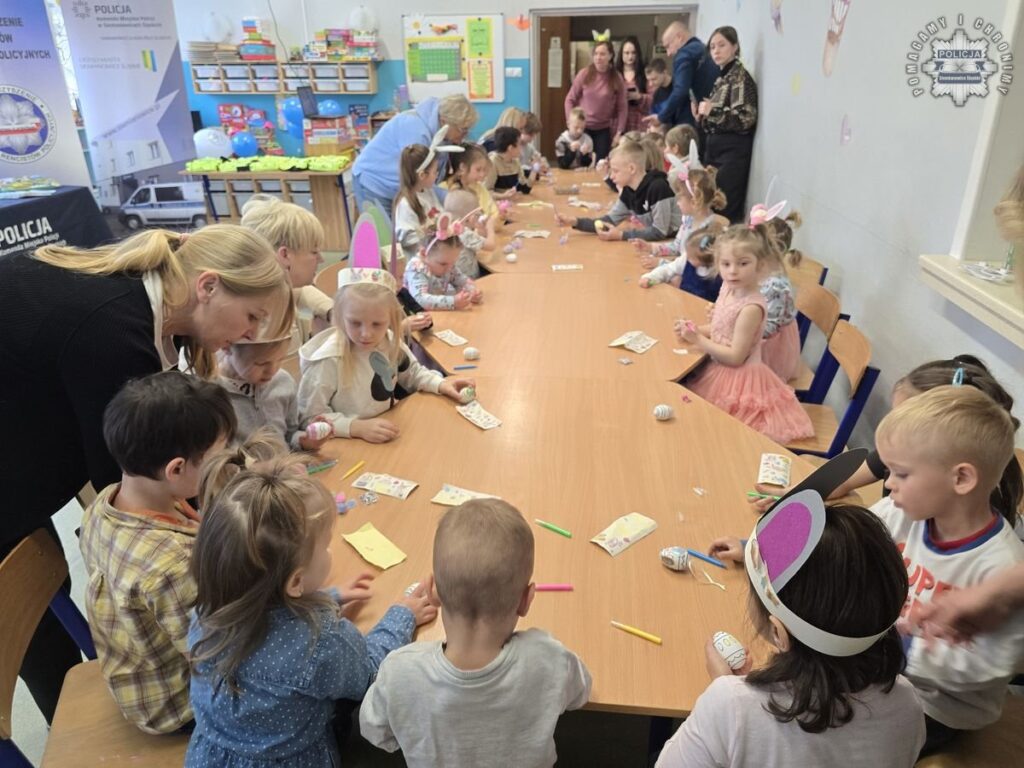 Dzieci siedzą przy stole i wykonują wielkanocne. ozdoby