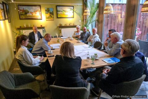 Ujęcie całej sali – przy stole siedzą przedstawiciele Aqua-Sprint i mieszkańcy, na stole dokumentacja i szklanki z wodą.