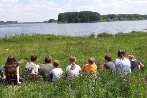 Dzieci siedzące na łące