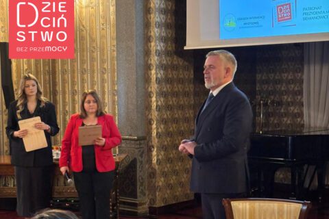 Dwie kobiety prowadzące warsztaty oraz mężczyzna, stoją przy fortepianie w Willi Fitznera, obok ekranu z prezentacją.