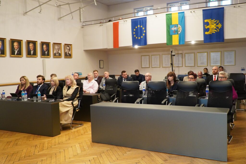 Radni oraz przedstawiciele samorządu siedzący przy stołach w sali obrad podczas 24. sesji Rady Miasta.