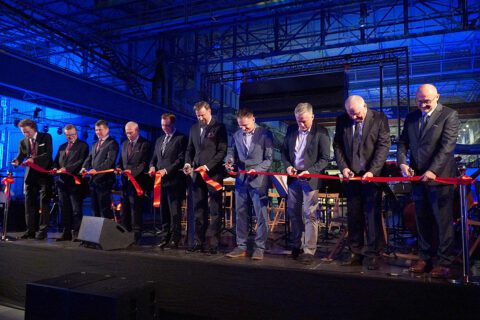 Dziesięciu przedstawicieli inwestora, władz miasta oraz wykonawcy stoi na scenie i jednocześnie przecina czerwoną wstęgę. Za nimi, na wprost publiczności, ustawiona orkiestra, mikrofony i industrialne tło. W tej chwili skupienie na twarzach ustępuje uśmiechom i uczuciu dumy.