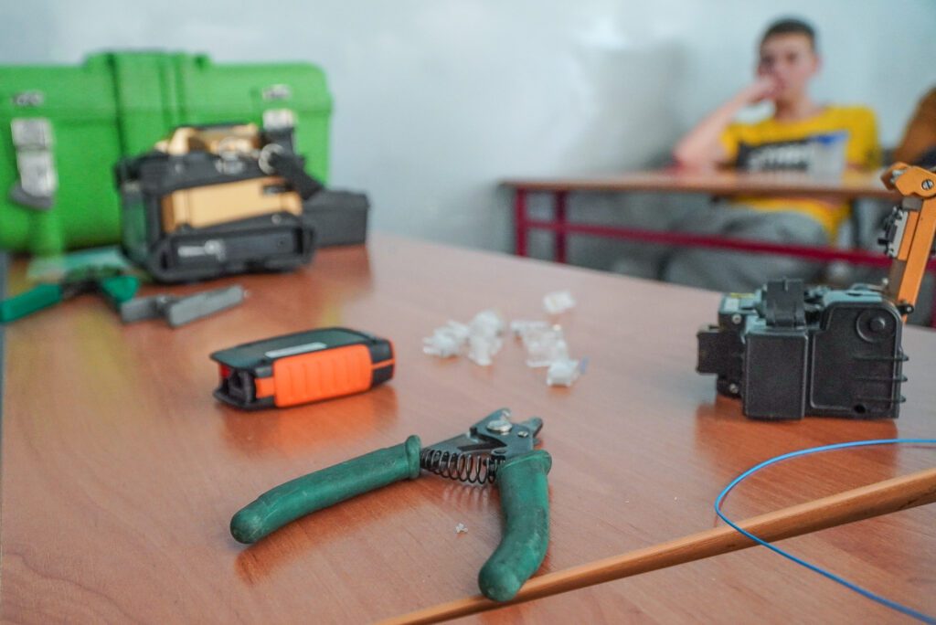 Stół z narzędziami i elementami do prac sieciowych w szkolnej klasie podczas warsztatów MMJ.