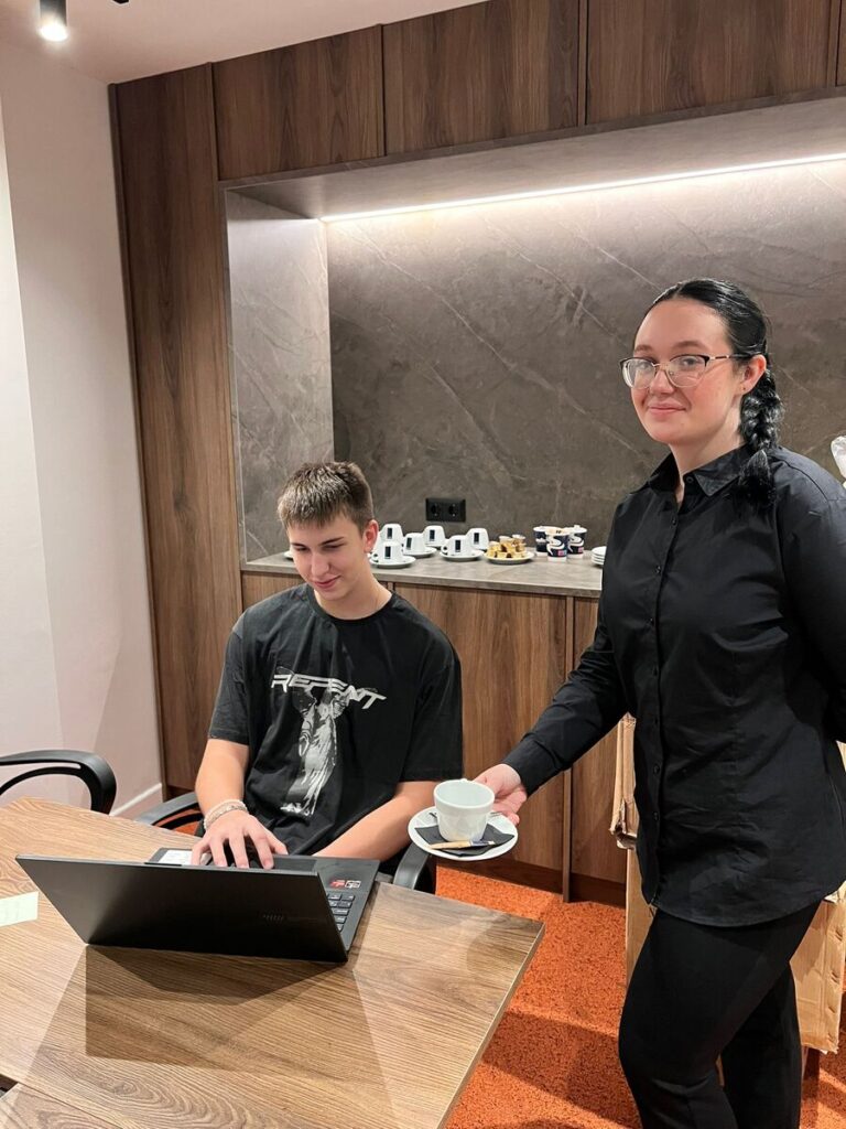 Dwoje uczniów ZS Cogito w zawodach technik reklamy i kelner w czasie praktyk zawodowych.