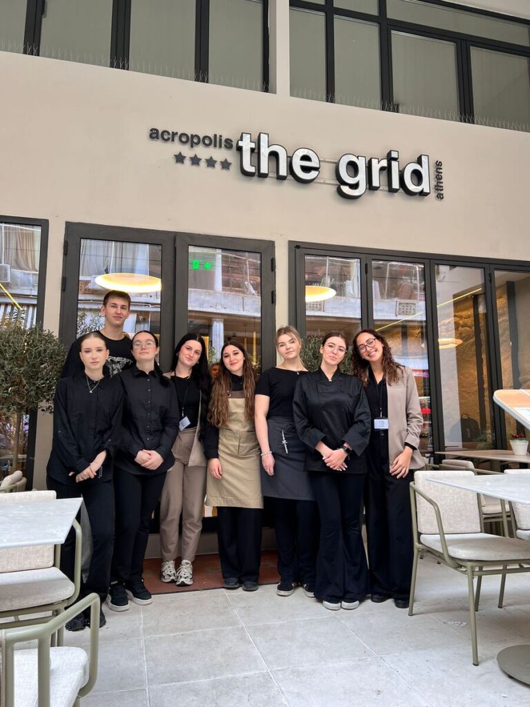 Pięcioro uczniów ZS Cogito pracujących w hotelu the grid przed wejściem.