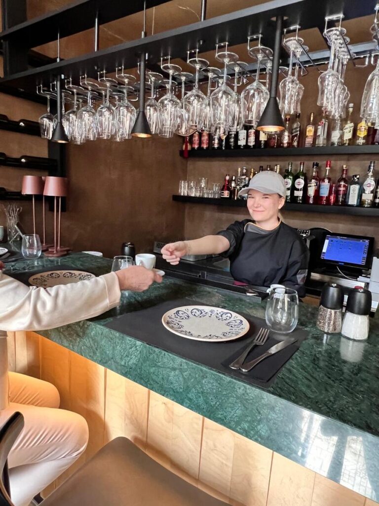 Uczennica ZS Cogito podaje kawę w trakcie praktyk.