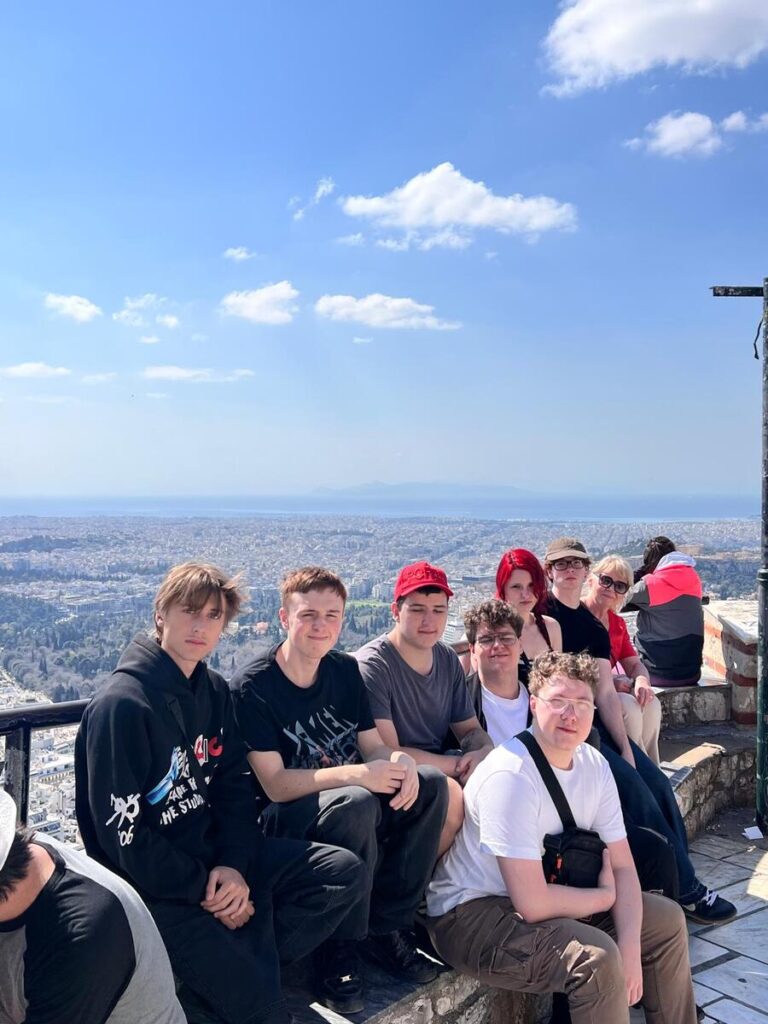uczniowie ZS Cogito wraz z opiekunem siedzą na szczycie Góry Lycabettus