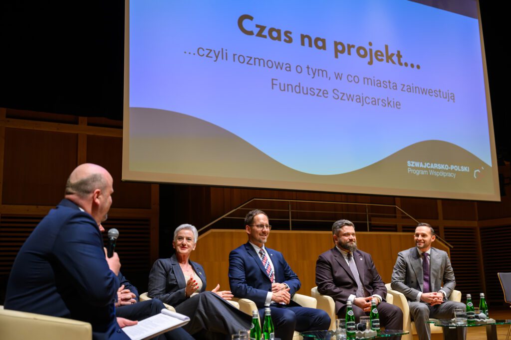 Grupa zaproszonych gości, przedstawicieli samorządu i resortu związanego z funduszami i polityką regionalną podczas rozmów/debaty.