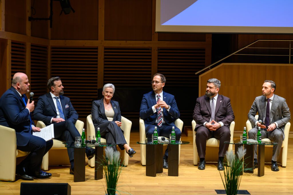 Grupa zaproszonych gości, przedstawicieli samorządu i resortu związanego z funduszami i polityką regionalną podczas rozmów/debaty.