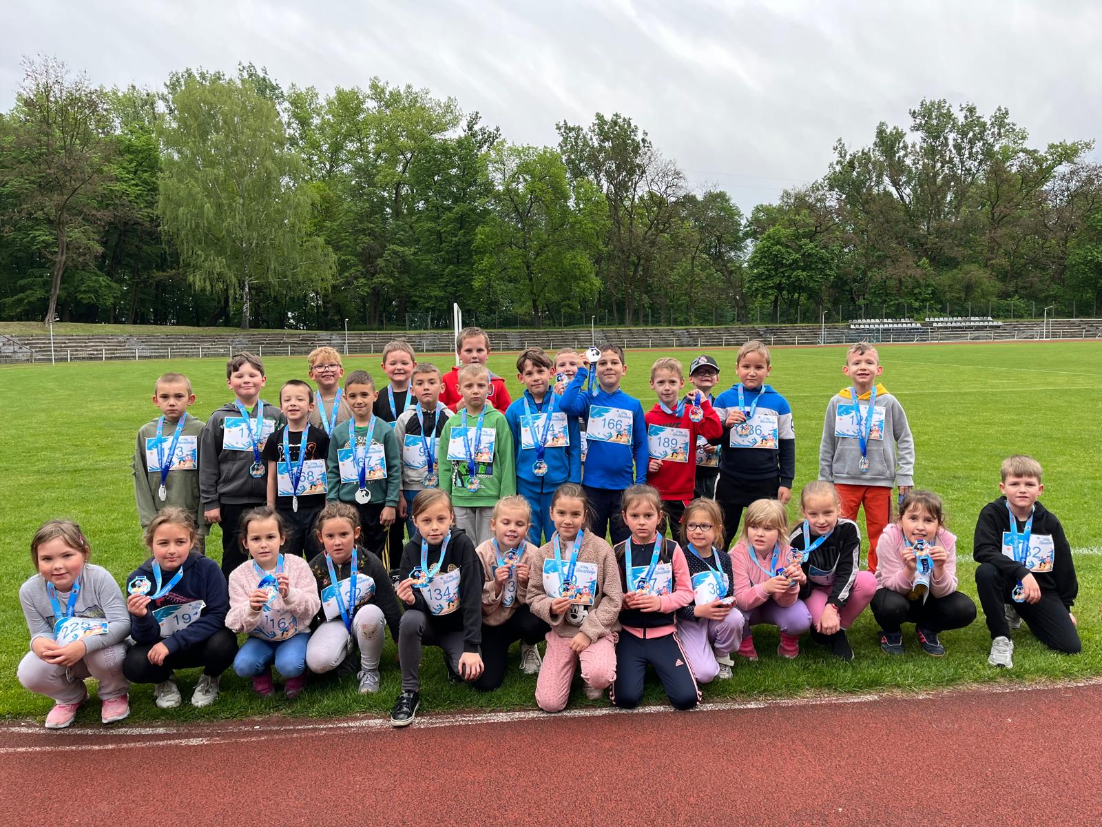 Uczniowie klas pierwszych uczestniczący w biegu na 400 m