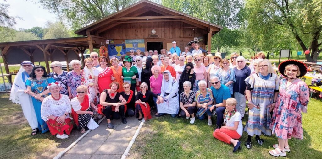 Uczestnicy spotkania organizowanego przez SUTW na Rzęsie w kolorowych strojach.