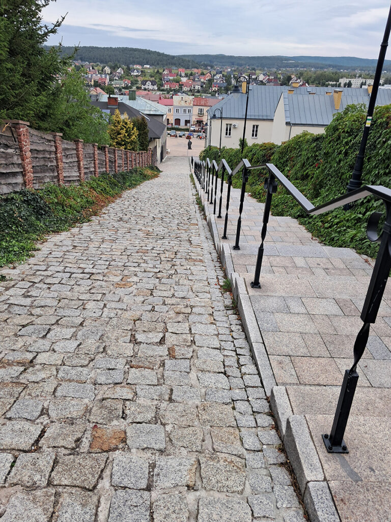 Widok z brukowanej uliczki prowadzącej ze wzgórza zamkowego na zabudowę Chęcin.