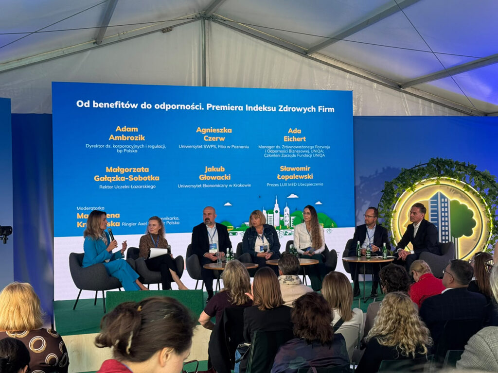 Panel „Od benefitów do odporności. Premiera Indeksu Zdrowych Firm” podczas Kongresu Zdrowe Miasta 2026. Siedmioro uczestników panelu dyskutuje na scenie przed zgromadzoną publicznością.