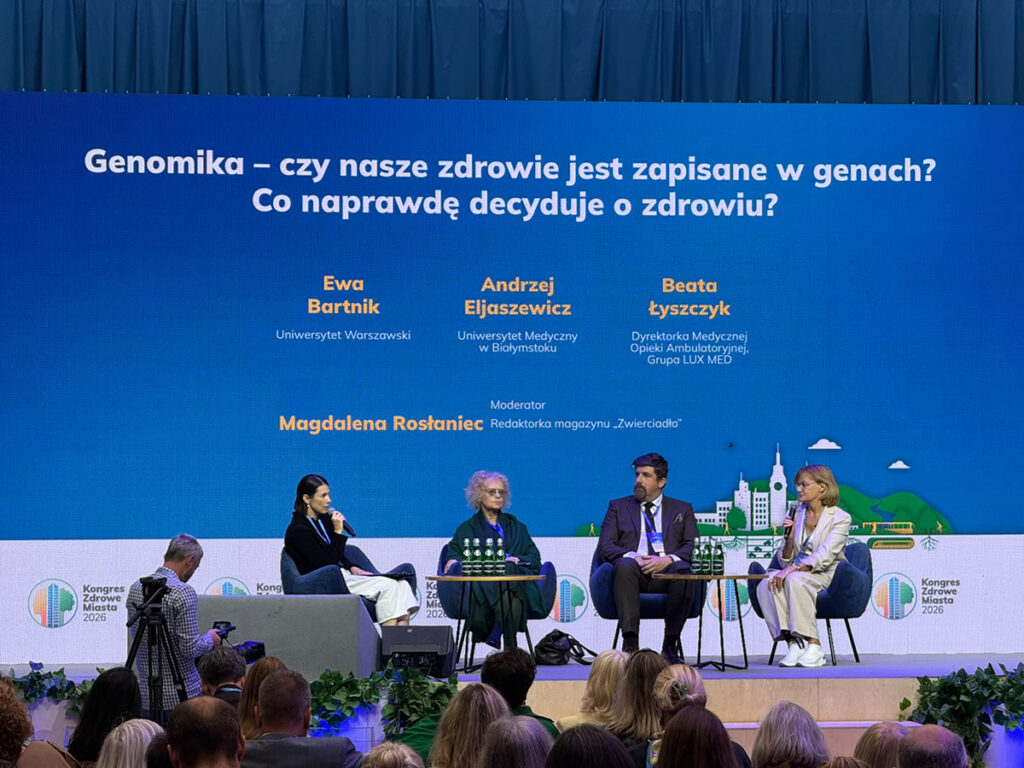 Panel dyskusyjny „Genomika – czy nasze zdrowie jest zapisane w genach? Co naprawdę decyduje o zdrowiu?” podczas Kongresu Zdrowe Miasta 2026. Na scenie cztery osoby uczestniczące w dyskusji.