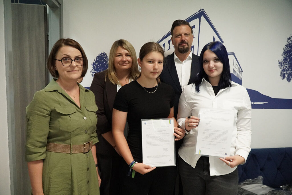 Uczniowie i dyrektor II LO pozują do zdjęcia z prezydentem miasta i jego zastępcą.