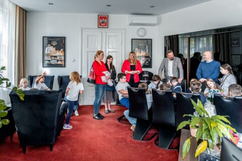Prezydent Siemianowic Śląskich oraz II Zastępca Prezydenta, Beata Gałecka, w swobodnej rozmowie z uczniami Szkoły Podstawowej nr 4 przy stole konferencyjnym.